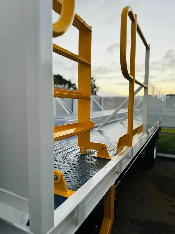 Close-up of fabricated yellow steel handrails on a vehicle deck