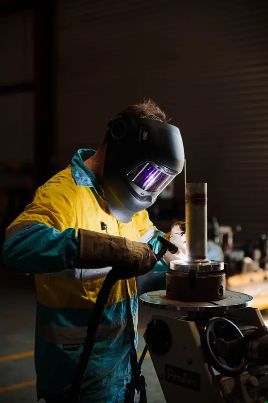 Welder in hi-vis at work in the Oxford Engineering fabrication workshop, Kwinana